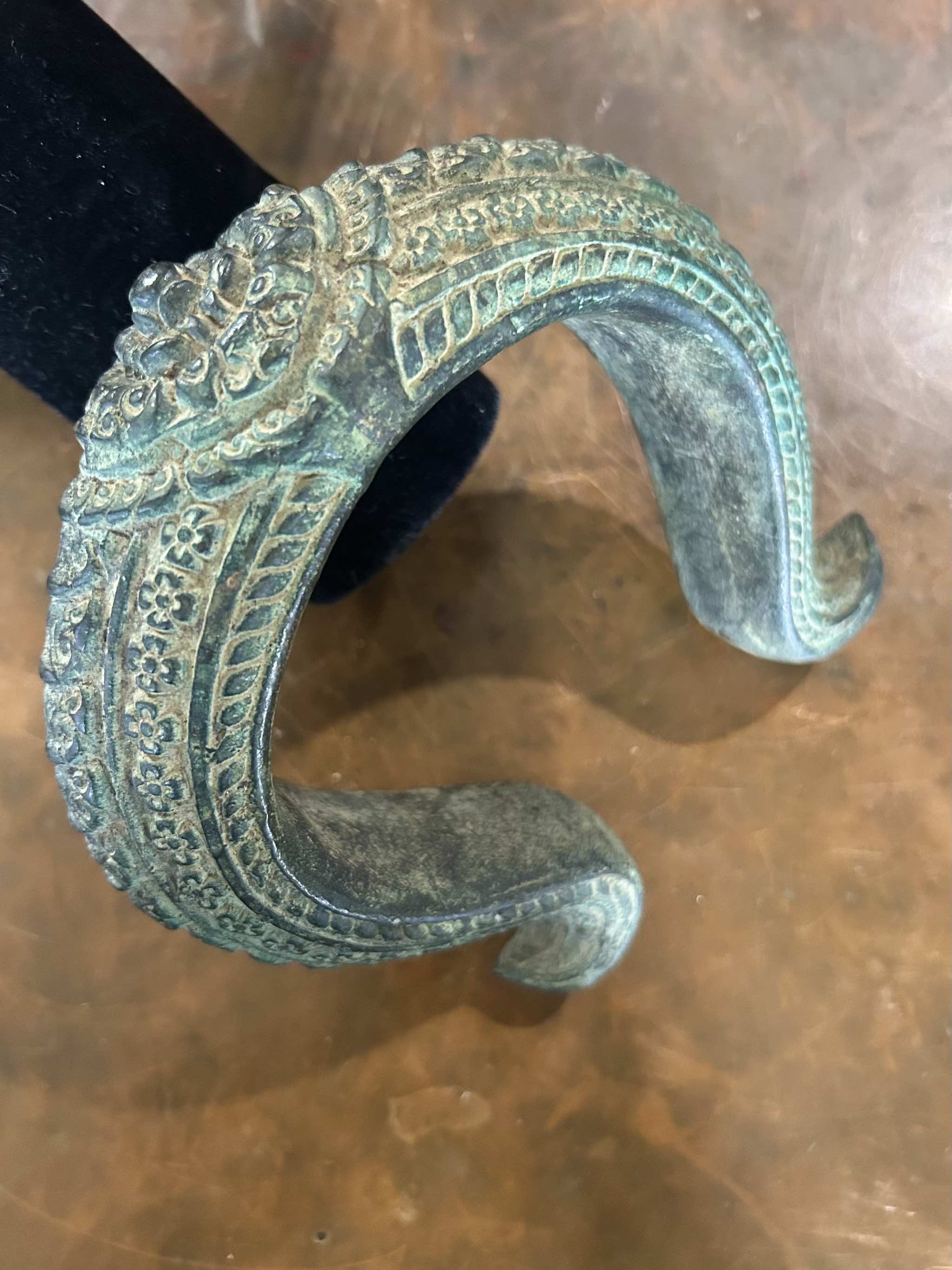 Antique bronze warrior bracelet on a brown surface