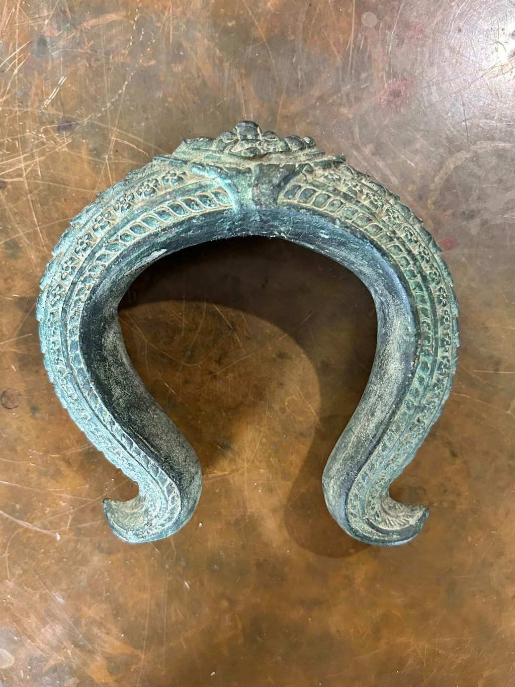 Antique bronze warrior bracelet on a brown surface