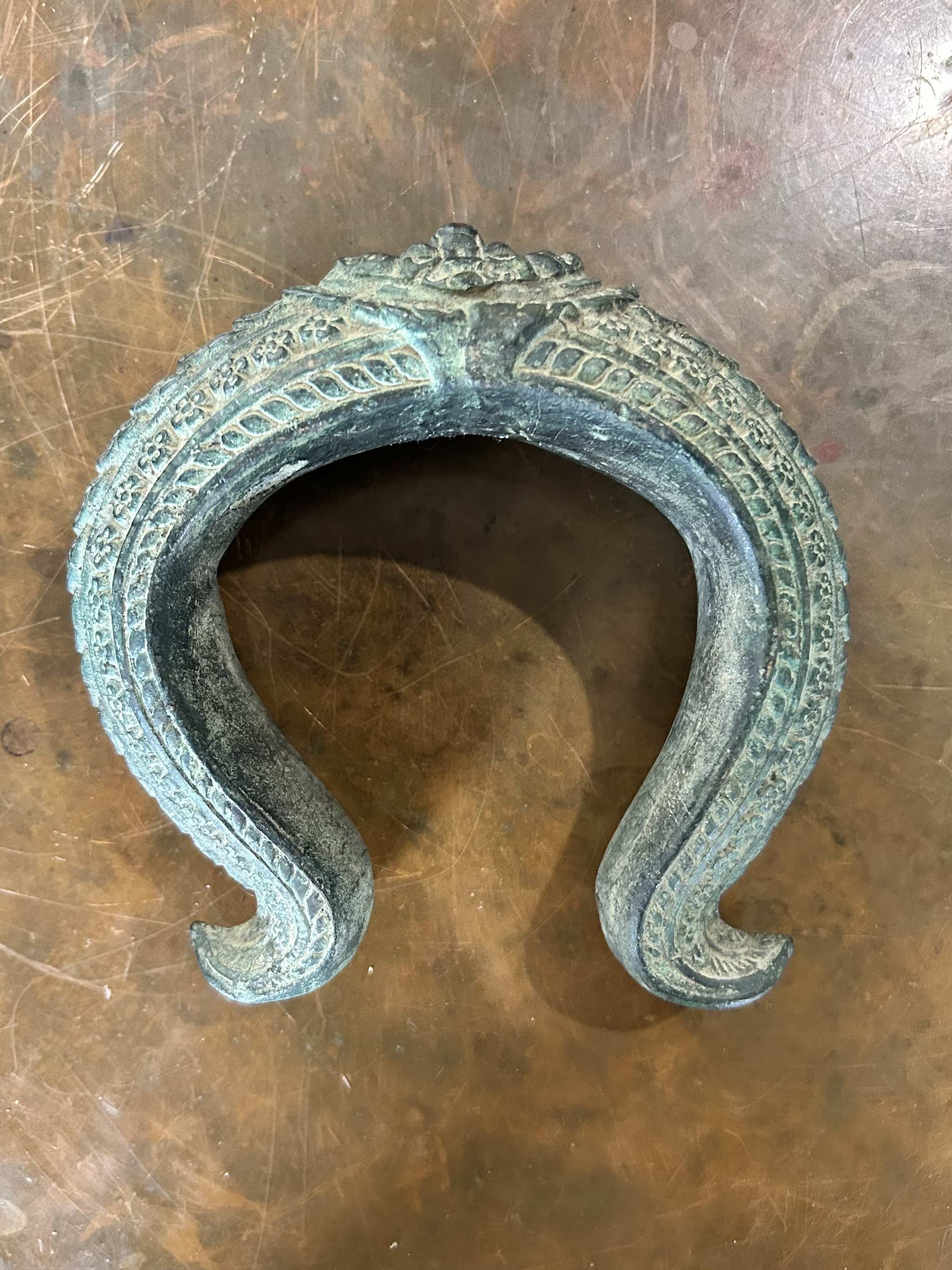 Antique bronze warrior bracelet on a brown surface