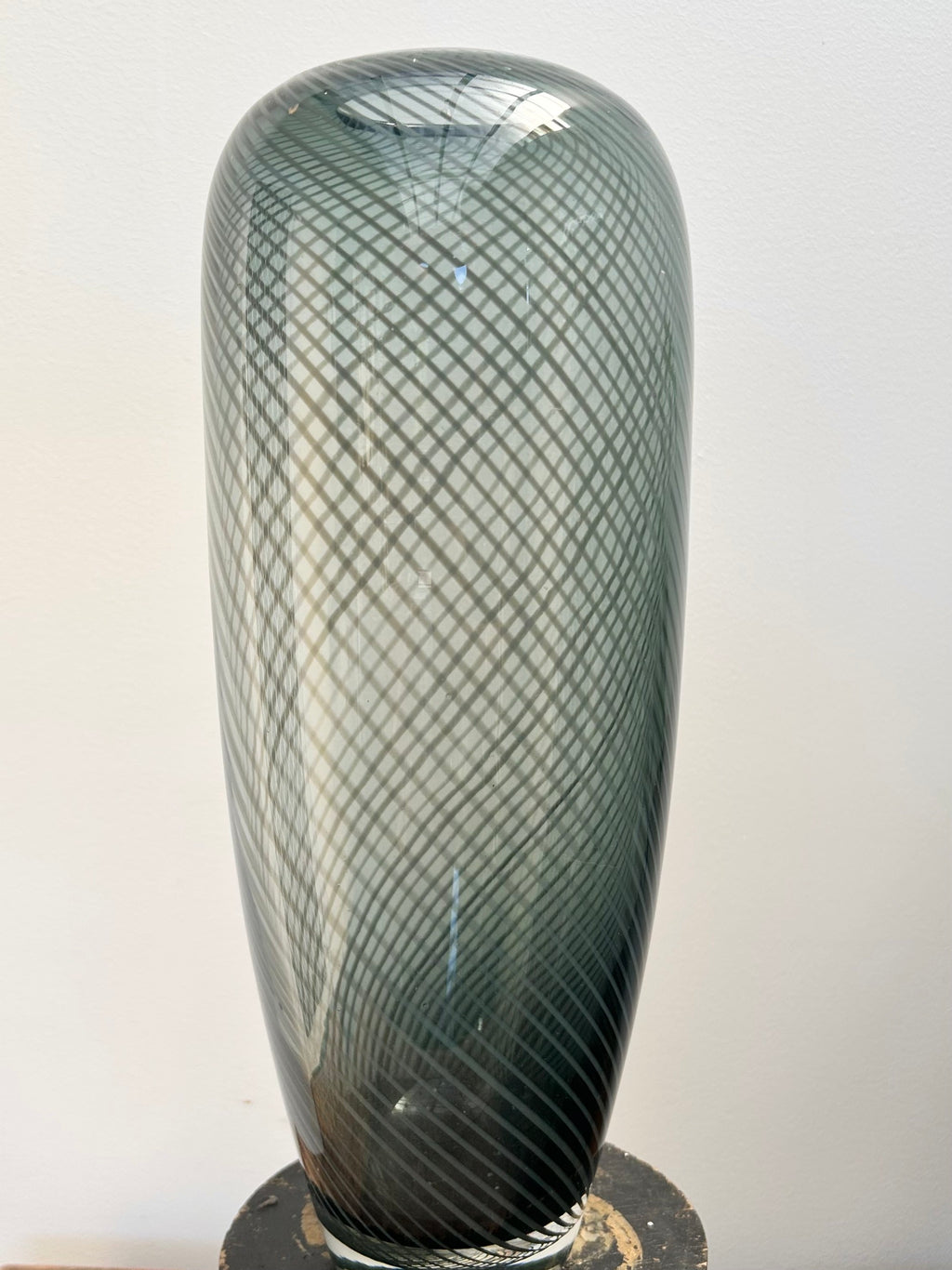 Tall glass vase with textured design on a white background